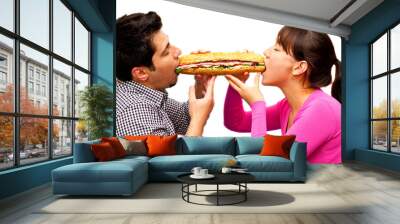 young man and a woman eating sandwich from two sides Wall mural