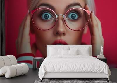 A young woman with blonde hair and blue eyes is wearing round glasses and has a surprised expression on her face. She is dressed in a red and white striped sweater. Wall mural