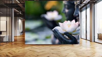 Close-up of a dark-skinned statue holding a white lotus flower, symbolizing serenity and purity. Wall mural