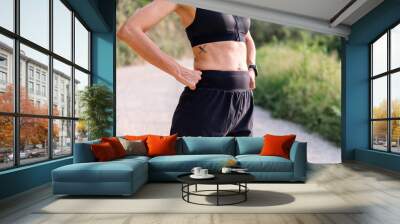 fitness body of an unrecognizable sporty woman in the countryside, concept of sport in nature and active lifestyle, copy space for text Wall mural