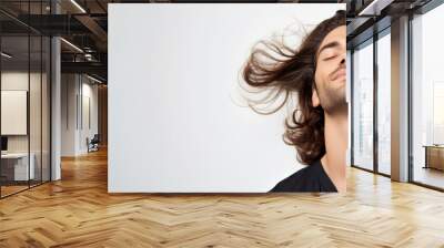 Sensual Male Model with Wind-Blown Wavy Brown Hair in Studio Portrait with Copy-Space Wall mural