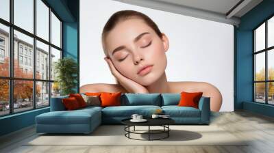 Front portrait shot of a model with closed eyes and clear skin on light background Wall mural