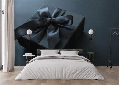 Black Friday Sale. Gift box with black ribbon isolated on black, close up Wall mural