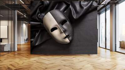 Carnival Venetian two faced mask, half black half silver on dark satin textile background, Wall mural