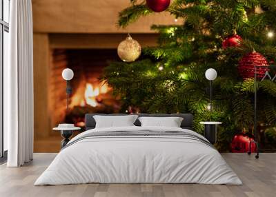 Christmas tree close up on burning fireplace background Wall mural