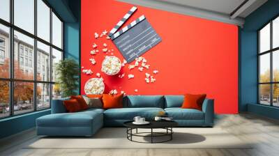 Clapperboard and pop corn on red color background, top view Wall mural