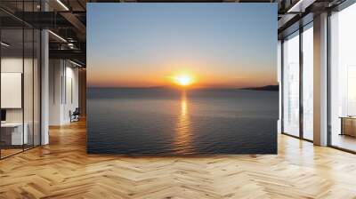 Sunset over Cyclades island Greece. Golden sun gets hide behind hill and colors gold sea water. Wall mural