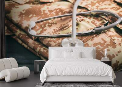 usa army health care. military digital pattern uniform and medical stethoscope on blue wooden backgr Wall mural