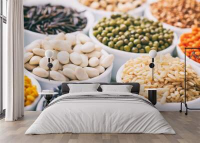 Various raw legumes and rice in bowls Wall mural