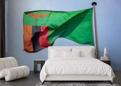 Zambia flag waving against clear blue sky Wall mural