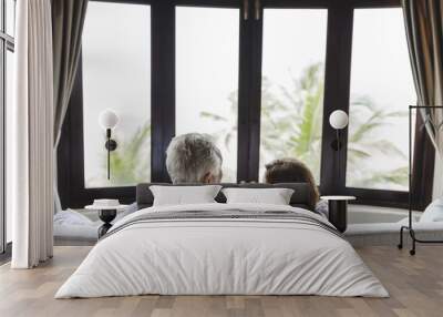 A senior couple sitting on a sofa Wall mural