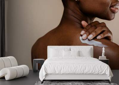 African woman applying lotion Wall mural