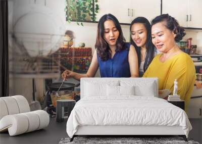 Asian family is cooking in the kitchen together Wall mural