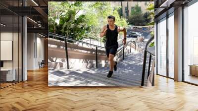 Asian man running up the steep stairs Wall mural