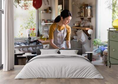 Asian woman busy cooking in the kitchen Wall mural