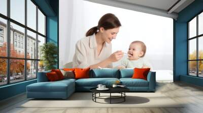 Baby eating adult spoon food. Wall mural