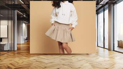 Cheerful asian kid wearing blank white embroidered polo sweatshirt and white contrast pleated skirt miniskirt child hairstyle. Wall mural