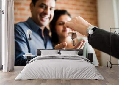 Cheerful couple with keys to their new home Wall mural