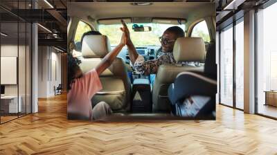 Cheerful family in a car on a road trip Wall mural