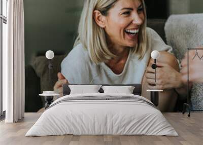 Cheerful woman talking with her boyfriend on the couch Wall mural