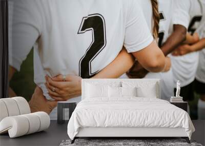 Close up of female football players huddling Wall mural