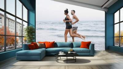 Couple jogging on a beach Wall mural