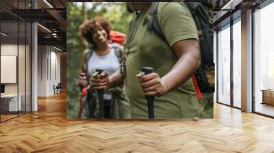 Couple trekking in the forest together Wall mural