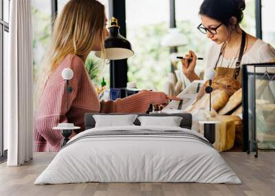 Customer ordering pastry at counter Wall mural