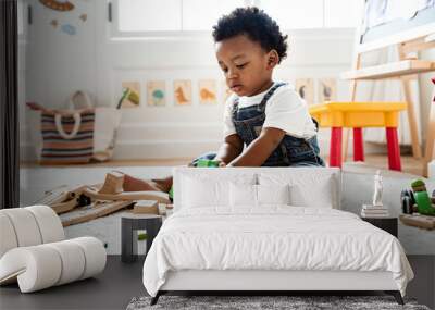 Cute little boy playing with a railroad train toy Wall mural