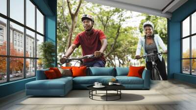 Cyclist couple riding together in a park Wall mural