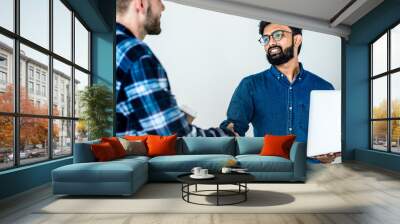 Diverse colleague men shaking hands together Wall mural