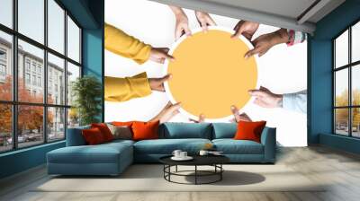 Diverse hands supporting a blank yellow round board Wall mural