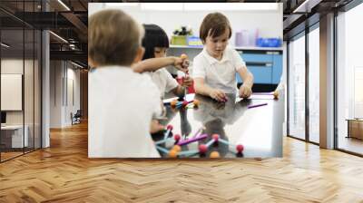 Diverse kindergarten students holding learning structures from toys Wall mural