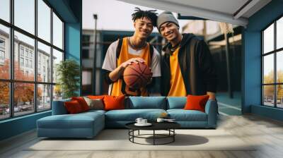 Diverse teen men wearing basketball team outfit smiling holding sports. Wall mural