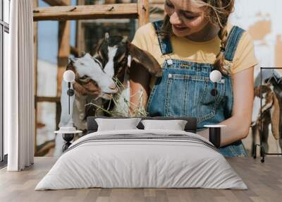 Farmer girl feeding the goats Wall mural