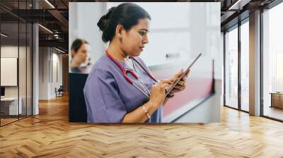 Female nurse checking the schedule on a tablet Wall mural