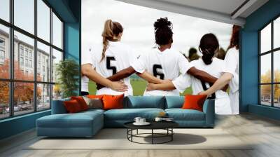 Female soccer players huddling and standing together Wall mural