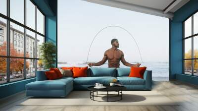 Fit man jumping rope at the beach Wall mural