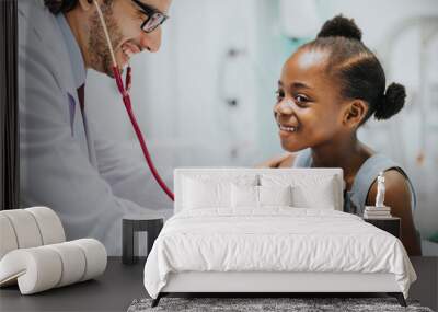 Friendly pediatrician checking a little girls heart Wall mural