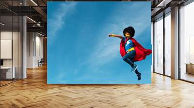 Girl with an afro playing superhero. Wall mural