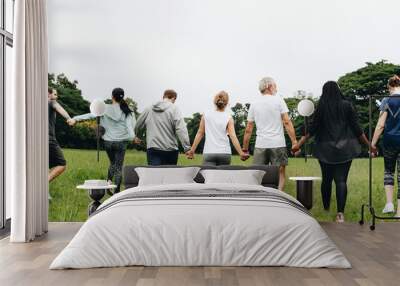 Group of adults holding hands in the park Wall mural