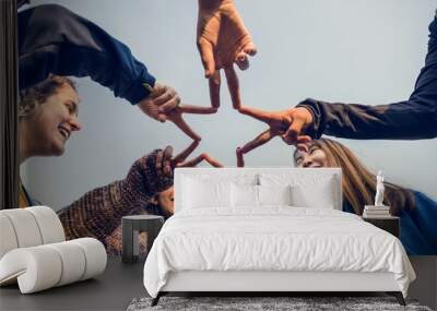 Group of friends using fingers to form the star shape teamwork and support concept Wall mural