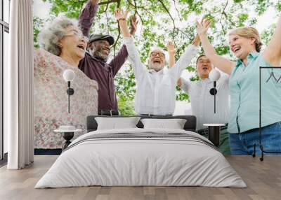 Group of happy retired senior friends  in the park cheering Wall mural