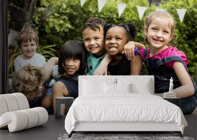 Group of kindergarten kids friends arm around sitting and smiling fun Wall mural