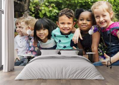 Group of kindergarten kids friends arm around sitting and smiling fun Wall mural