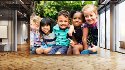 Group of kindergarten kids friends arm around sitting and smiling fun Wall mural