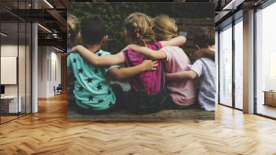 Group of kindergarten kids friends arm around sitting together Wall mural