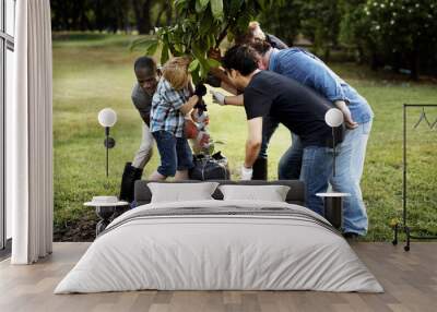 Group of people plant a tree together outdoors Wall mural