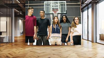 Group of young teenager friends on a basketball court standing in a row Wall mural