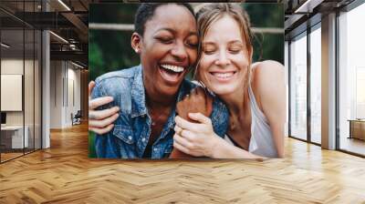 Happy black woman laughing with her friend Wall mural